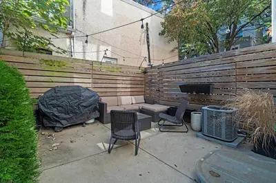 a patio with two chairs and a grill and a fence at Getaway in the heart of the city in Philadelphia