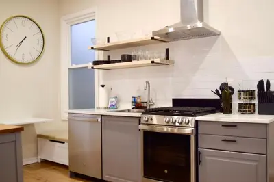 a kitchen with a stove and a clock on the wall at Newly Renovated 1 Bedroom Executive Apartment in Kearny
