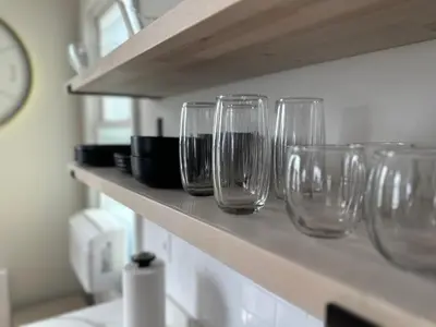 a row of wine glasses sitting on a shelf at Newly Renovated 1 Bedroom Executive Apartment in Kearny