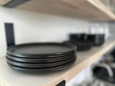 a stack of black plates sitting on a shelf at Newly Renovated 1 Bedroom Executive Apartment in Kearny