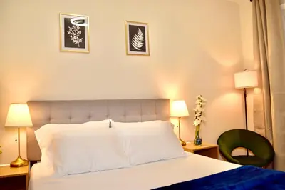 a bedroom with a bed with two lamps and a chair at Newly Renovated 1 Bedroom Executive Apartment in Kearny