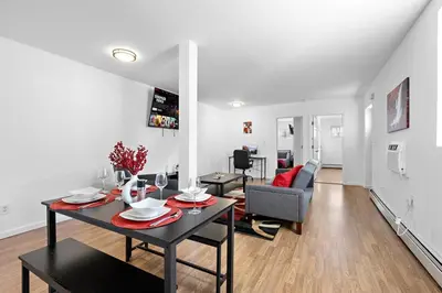 a living room with a table and a dining room at Cozy Family Getaway - NYC & NWK with free parking in Bayonne