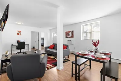 a living room with a couch and a table at Cozy Family Getaway - NYC & NWK with free parking in Bayonne
