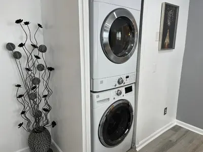 two washer and dryer machines in a room at Spacious 3 bedroom close to NYC in North Bergen