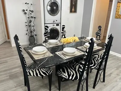 a dining room table with zebra chairs and a table with plates at Spacious 3 bedroom close to NYC in North Bergen