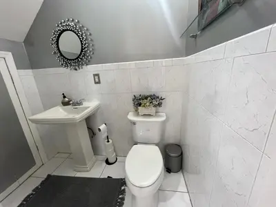 a white bathroom with a toilet and a sink at Spacious 3 bedroom close to NYC in North Bergen