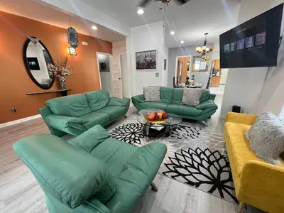 a living room with green couches and a table at Spacious 3 bedroom close to NYC in North Bergen
