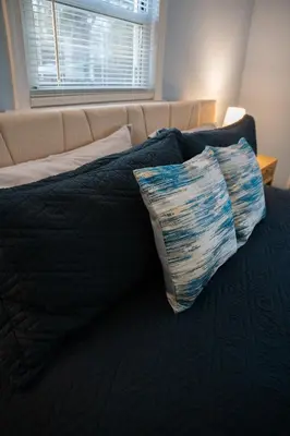 a bed with a pillow sitting on top of it at Cozy Pocono Home with a Hot Tub, Fire pit, Karaoke, Games and more! in Albrightsville