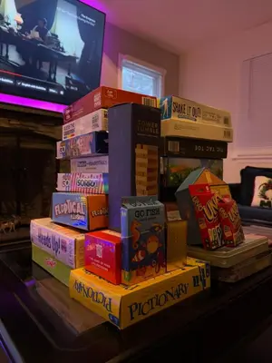 a pile of books sitting on top of a table at Cozy Pocono Home with a Hot Tub, Fire pit, Karaoke, Games and more! in Albrightsville
