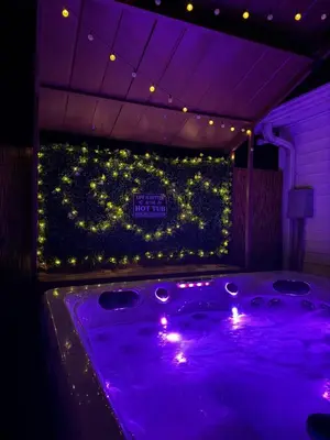 a jacuzzi tub in a room with purple lighting at Cozy Pocono Home with a Hot Tub, Fire pit, Karaoke, Games and more! in Albrightsville