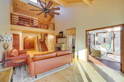 a living room with a couch and a ceiling fan at Ski, Hike and More Spacious Log Cabin in Long Pond in Long Pond