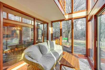 a living room with a white couch and some windows at Ski, Hike and More Spacious Log Cabin in Long Pond in Long Pond