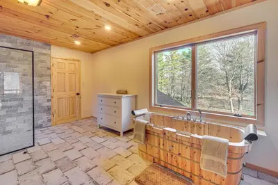 a bathroom with a large tub and a window at Ski, Hike and More Spacious Log Cabin in Long Pond in Long Pond