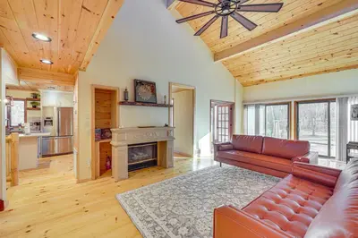 a living room with a couch and a fireplace at Ski, Hike and More Spacious Log Cabin in Long Pond in Long Pond