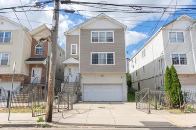 a house with a garage in a residential neighborhood at 3-Bedroom Apt 5 miles AirPort in Newark