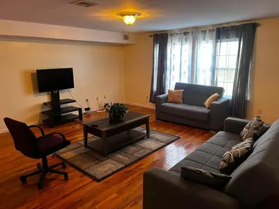 a living room with a couch and a tv at 3-Bedroom Apt 5 miles AirPort in Newark