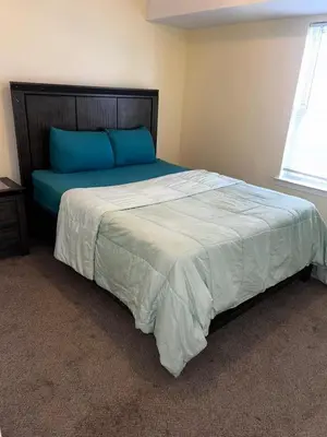 a bedroom with a large bed with blue pillows at 3-Bedroom Apt 5 miles AirPort in Newark