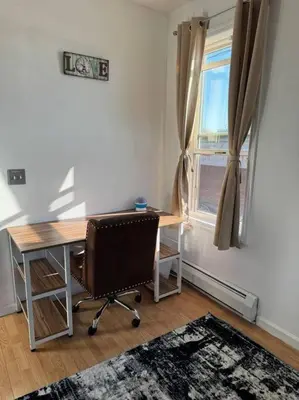 an office with a desk and a chair and a window at For NYC visitors 9min to NYC train-15min to EWR in Bayonne