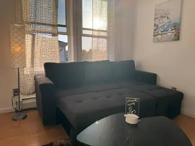 a living room with a couch and a table at For NYC visitors 9min to NYC train-15min to EWR in Bayonne