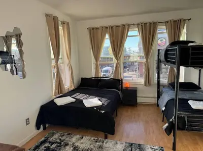 a bedroom with a bed and a bunk bed at For NYC visitors 9min to NYC train-15min to EWR in Bayonne