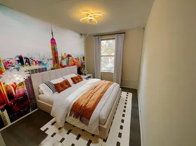 a bedroom with a large bed with a painting on the wall at Manhattan Skyline Mins to TimeSQ in West New York