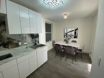 a kitchen with a sink and a table with chairs at Manhattan Skyline Mins to TimeSQ in West New York