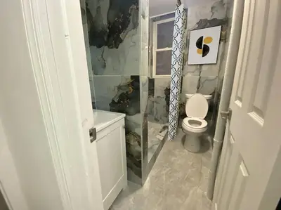 a bathroom with a toilet and a sink at Manhattan Skyline Mins to TimeSQ in West New York