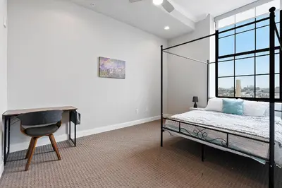 a bedroom with a bed and a desk and a window at High-End 1BR with Rooftop Amenities in Philadelphia