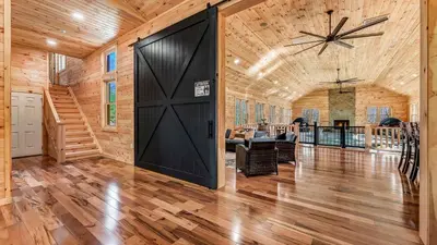 a large black door in a room with wooden walls at Grand Timber by AvantStay Indoor Pool Sports Court Game Room More in White Haven