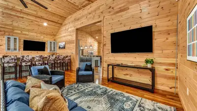 a living room with a large fireplace and a flat screen tv at Grand Timber by AvantStay Indoor Pool Sports Court Game Room More in White Haven
