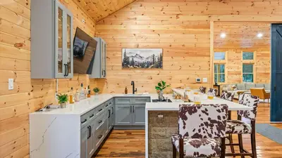 a kitchen with wooden walls and wooden floors at Grand Timber by AvantStay Indoor Pool Sports Court Game Room More in White Haven