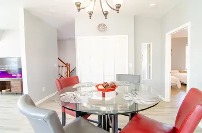 a dining room with a glass table and red chairs at Near NYC Spacious 4 bedroom 2 and a half bath in North Bergen