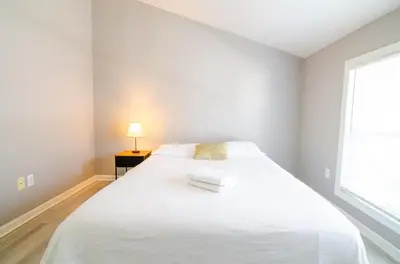 a white bed in a white room with a window at Near NYC Spacious 4 bedroom 2 and a half bath in North Bergen