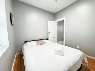 a bedroom with a large white bed in it at 3 bed 1 bath FREE parking near NYC in North Bergen