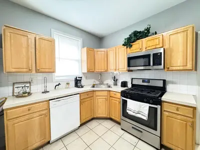 a kitchen with white appliances and wooden cabinets at 3 bed 1 bath FREE parking near NYC in North Bergen