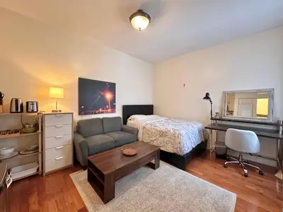 a bedroom with a bed and a couch and a desk at Urban Luxury Hudson River Suite in New York