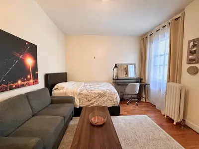 a living room with a couch and a bed at Urban Luxury Hudson River Suite in New York