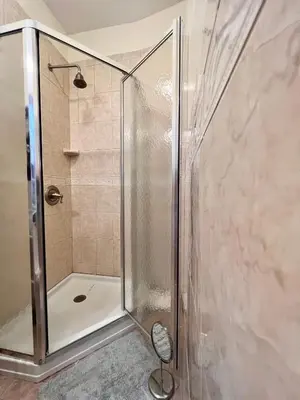 a shower with a glass door in a bathroom at Urban Luxury Hudson River Suite in New York
