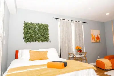 a bedroom with a bed with orange pillows at The Philly Factory! in Philadelphia