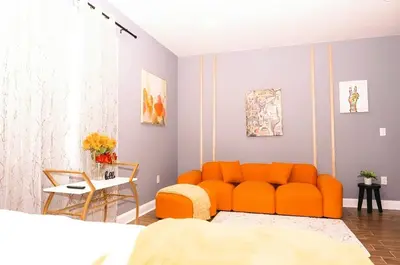 an orange couch in a room with a bedroom at The Philly Factory! in Philadelphia