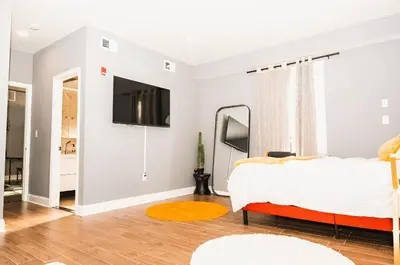 a bedroom with a bed and a tv on a wall at The Philly Factory! in Philadelphia