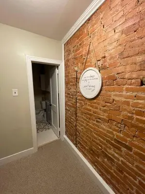 a room with a brick wall with a clock on it at House of the Heart at Trolley Square! in Wilmington