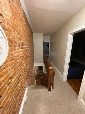 a room with a brick wall and a clock on a wall at House of the Heart at Trolley Square! in Wilmington