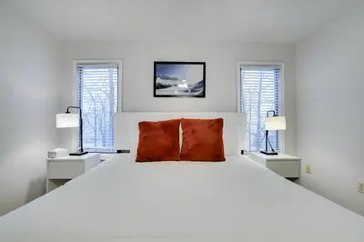 a white bedroom with a large white bed with two windows at Lake Harmony Retreat Perfect Family Getaway in Lake Harmony