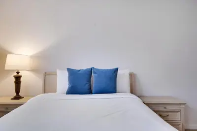 a white bed with blue pillows in a bedroom at Lake Harmony Retreat Perfect Family Getaway in Lake Harmony