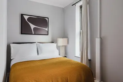 a bedroom with a bed with a yellow blanket at Blueground Gramercy Park 2bd apartment NYC-1616 in New York
