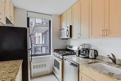 a kitchen with a stove top oven next to a sink at Blueground Midtown West 1bd apartment NYC-1625 in New York