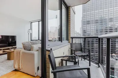 a living room with a couch and chairs on a balcony at Blueground Midtown West 1bd apartment NYC-1625 in New York