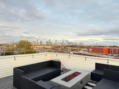a balcony with two chairs and a couch on a building at Stunning NYC rooftop views minutes away from NYC 2 bedroom 2 bath in Jersey City