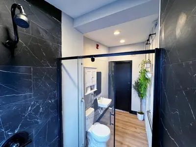 a bathroom with a shower with a toilet and a sink at Bright & New Room Shared Apartment NYC Bus in Englewood